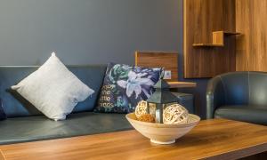 a living room with a couch and a table with a bowl on it at Hotel Calipso Hotel in Sofia