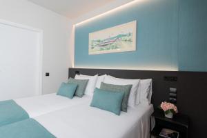 a bedroom with two beds with blue and white at Aparthotel Atenea Barcelona in Barcelona