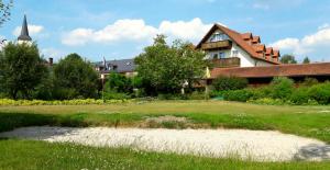 a house with a beach in front of a building at Hotel Wiesend in Kulmain