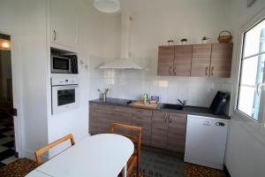 a kitchen with wooden cabinets and a counter top at Lovely house with Garden and Terrace very close to the beach in Hourtin