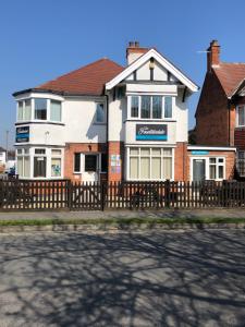 a house with a wooden fence in front of it at The Fountaindale Skegness in Skegness
