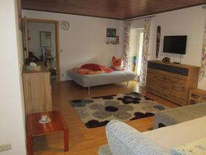 a living room with a cat laying on a bed at Ferienwohnung Sabine in Obergessertshausen