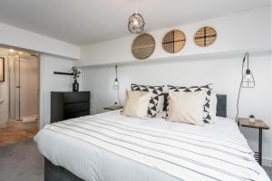 una camera da letto con un grande letto bianco con cuscini di Granary Suite No22 - Donnini Apartments ad Ayr