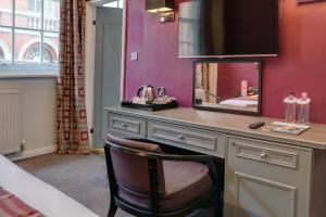a living room with a tv and a chair at St James Hotel; BW Premier Collection in Nottingham
