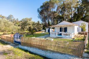 una casa bianca con una recinzione accanto a un fiume di Blue House a Dafnila