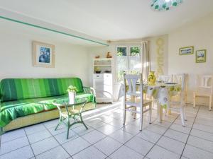 ラ・フロットにあるModern Holiday Home in Sainte-Marie-de-Re near Seaのリビングルーム(緑のソファ、テーブル付)