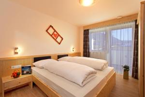 a bedroom with two beds and a window at Stiflerhof in Falzes