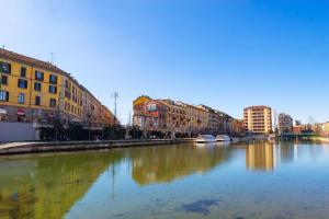 um rio numa cidade com edifícios e edifícios em LUVI - Alzaia Naviglio Pavese em Milão