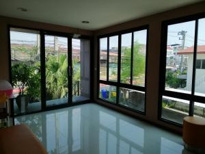 a room with large windows and a view of the city at ศรีกรุงดีลักซ์โฮเตล in Phra Nakhon Si Ayutthaya