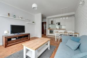 a living room with a couch and a tv at Willa Morska Superior by Grand Apartments in Sopot