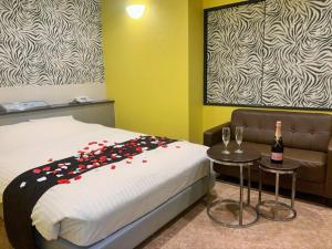 Hotel NewMie (Adult Only) في طوكيو: غرفة نوم مع سرير مع زجاجة من الشمبانيا