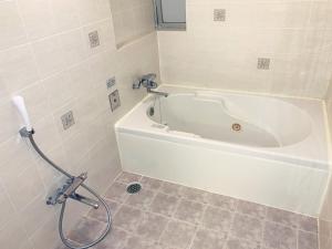 a white bath tub in a bathroom with at Hotel NewMie (Adult Only) in Tokyo