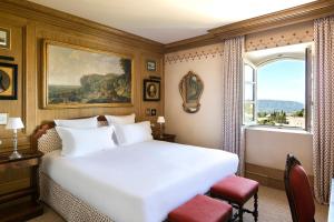 a bedroom with a large white bed and a window at Airelles Gordes, La Bastide in Gordes