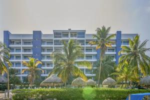 科韋尼亞斯的住宿－Hermoso Apartamento Frente al Mar 2 Habitaciones PAZ146，一座棕榈树环绕的大建筑