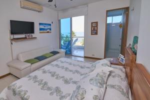 Sala de estar con cama, sofá y TV en Hermoso Apartamento Frente al Mar 2 Habitaciones PAZ146, en Coveñas