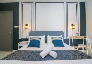 1 dormitorio con 1 cama grande con almohadas azules y blancas en Suasana Residence by Nest Home, en Johor Bahru