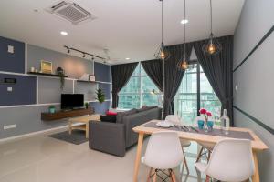 - un salon avec une table, des chaises et un canapé dans l'établissement Suasana Residence by Nest Home, à Johor Bahru