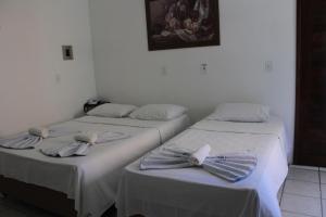 2 camas con lazos de arco en una habitación en Hotel Rio Preguiças en Barreirinhas