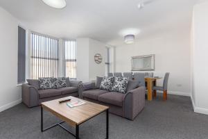 a living room with two couches and a table at Heritage House Apartments - Blackpool Resort Collection in Blackpool