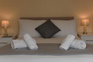 a bed with rolled towels on it with two lamps at Dartside 2 in Dartmouth
