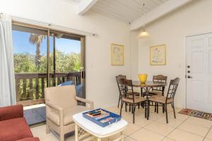sala de estar con mesa y sillas y balcón en Tiki 202, en South Padre Island