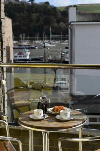 une table avec une assiette de nourriture et deux tasses de café dans l'établissement Dartside 3, à Dartmouth