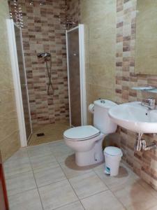 uma casa de banho com um WC, um chuveiro e um lavatório. em Hostal la Campa em Chiclana de la Frontera