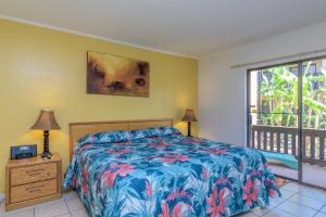 ein Schlafzimmer mit einem Bett mit einer farbenfrohen Tagesdecke in der Unterkunft Tiki 157 in South Padre Island