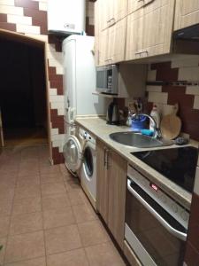 een keuken met een koelkast, een wastafel en een vaatwasser bij Guest House Pid Dubom in Lviv