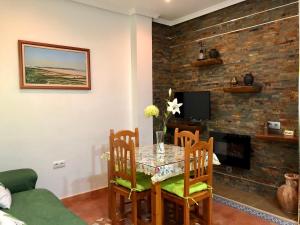 Apartamento Triana l Bolonia, Tarifa في بولونيا: غرفة طعام مع طاولة وكراسي ومدفأة