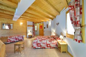 1 dormitorio en una cabaña de madera con 1 cama y 1 mesa en Hotel L'espoir, en Champoluc