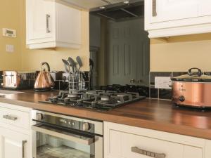 a kitchen with a stove and a pot on the counter at Arbour Retreat in Filey