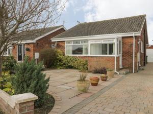 a brick house with a patio in front of it at Arbour Retreat in Filey