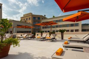 un patio avec des tables, des chaises et des parasols dans l'établissement Grand Hotel Castrocaro Longlife Formula, à Castrocaro Terme