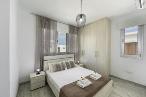 Un dormitorio con dos camas con toallas encima. en Protaras Villa Alasia, en Protaras 28 fotos más