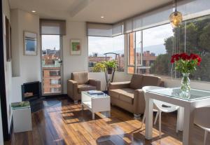 ein Wohnzimmer mit einem Sofa und einem Tisch in der Unterkunft Hotel 104 Art Suites in Bogotá