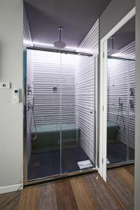 une salle de bain avec une douche avec une porte vitrée dans l'établissement Ara Suite, à Rome 35 autres photos