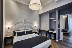 une chambre avec un grand lit et un bureau dans l'établissement Ara Suite, à Rome
