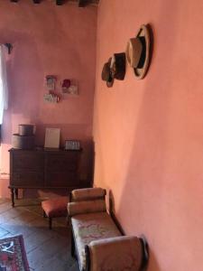 a living room filled with furniture next to a wall at La Locanda del Loggiato in Bagno Vignoni