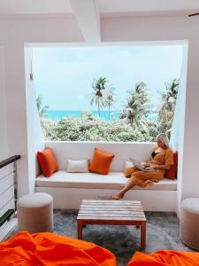 a woman sitting on a couch looking out a window at Bliss Dhigurah in Dhigurah