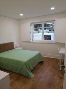 a bedroom with a green bed and a window at 4-As Moradias Centro in Guimarães +32 photos