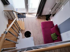 sala de estar con silla rosa y escaleras en Feldhouse, en Bremen