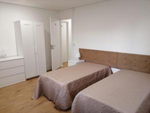 a small room with two beds and a window at 4-As Moradias Centro in Guimarães