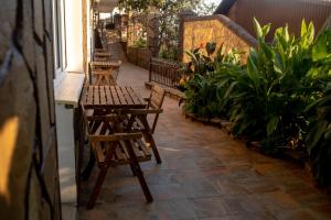 a patio with wooden chairs and tables and plants at Guest House on Suvorova in Lazarevskoye