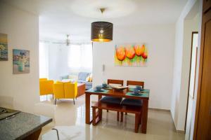 a living room with a table and yellow chairs at Modern 3 Bedroom Apt with Wifi and AC Near Airport and Major Areas in Santiago de los Caballeros