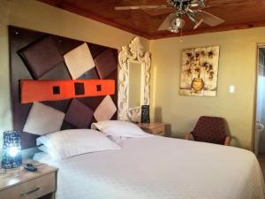 a bedroom with a large white bed and a ceiling at Max B&B in East London