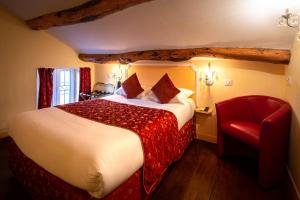 a hotel room with a bed and a red chair at Hôtel U Palazzu & Spa - Centre du village in Venaco
