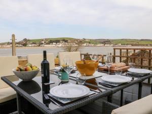 a table with plates and wine glasses on a balcony at The Light House in Bideford