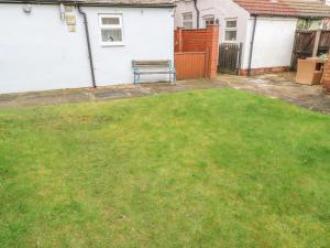 einen Hinterhof mit einer Bank im Gras in der Unterkunft Hazelmere Cottage in Worksop