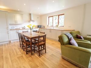 a kitchen and dining room with a table and a couch at The Alders in Llanfyllin